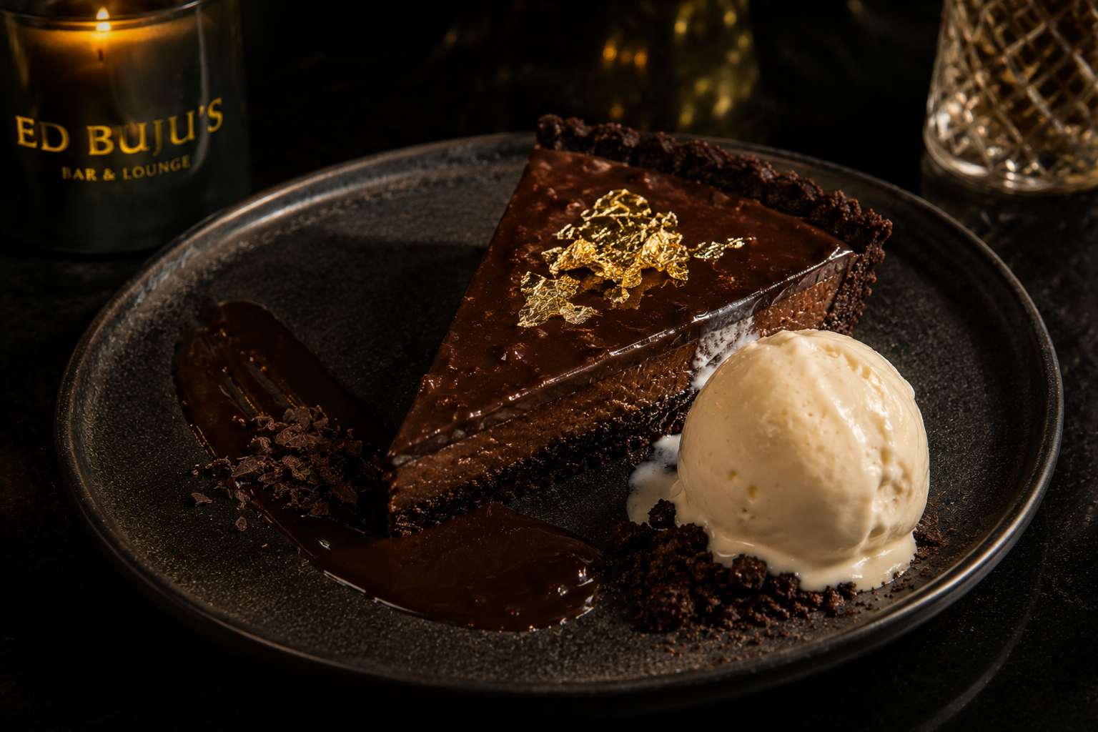 Dark chocolate rum tart with gold leaf and vanilla ice cream